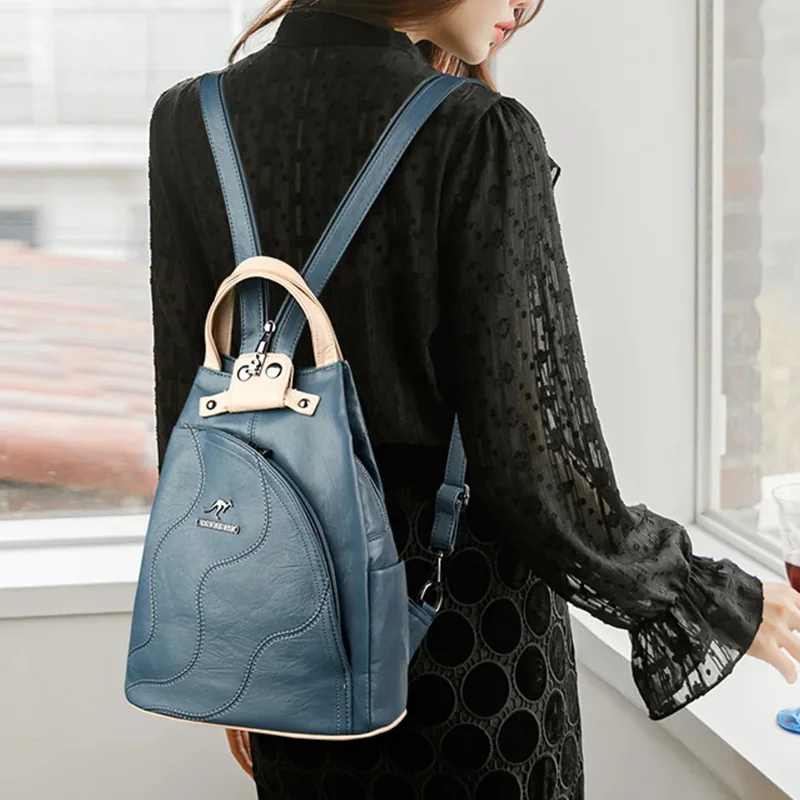A woman wearing a black blouse and a dark blue backpack.