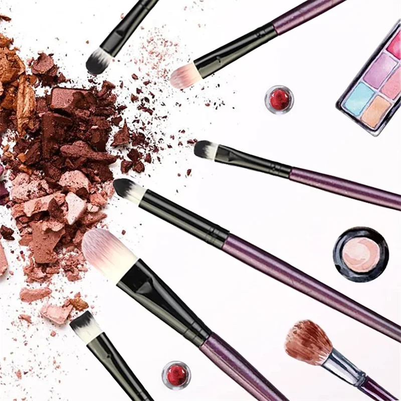 A collection of makeup brushes arranged around crushed eyeshadow on a white background.