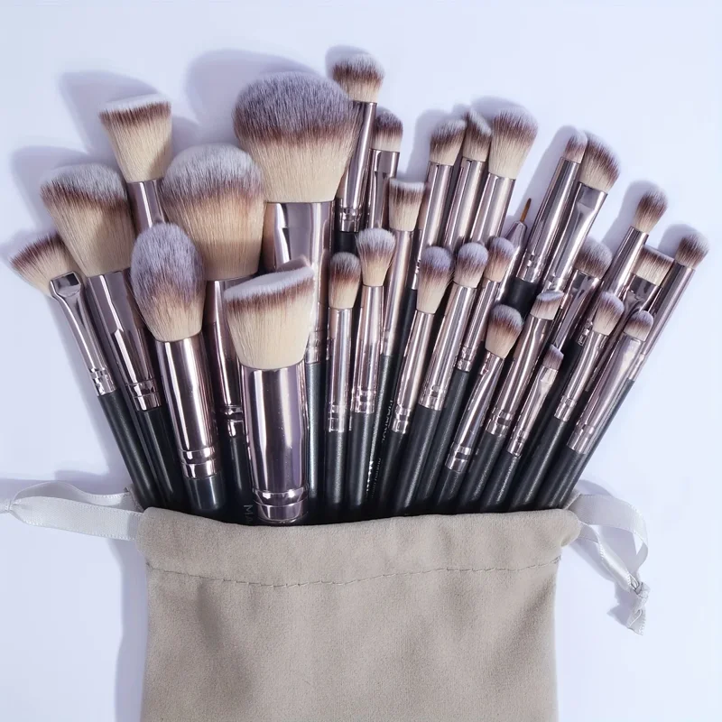 A large collection of makeup brushes in a beige drawstring bag.
