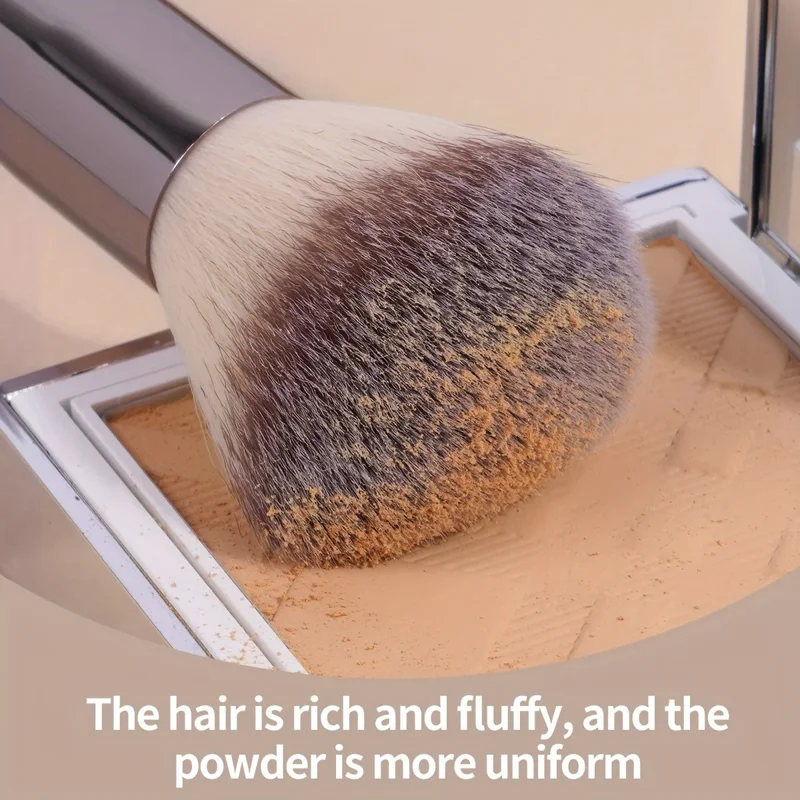 Close-up of a makeup brush with fluffy bristles picking up powder from a compact. The text overlay reads, 'The hair is rich and fluffy, and the powder is more uniform.'