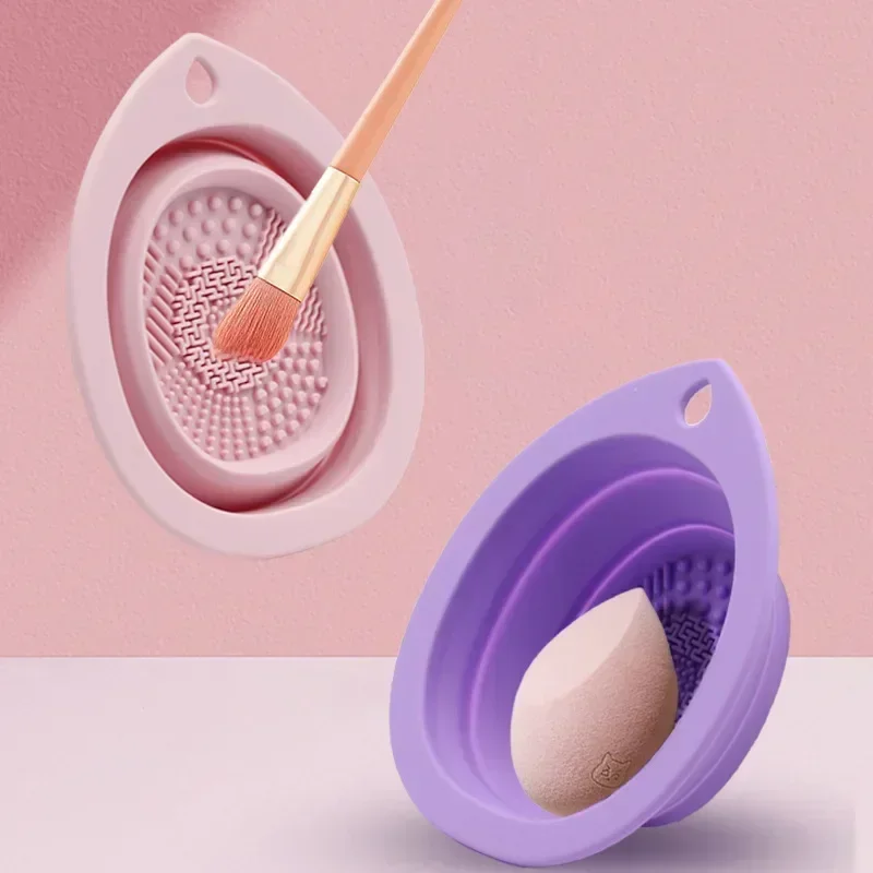 Two silicone makeup brush and sponge cleaning bowls in pink and purple.