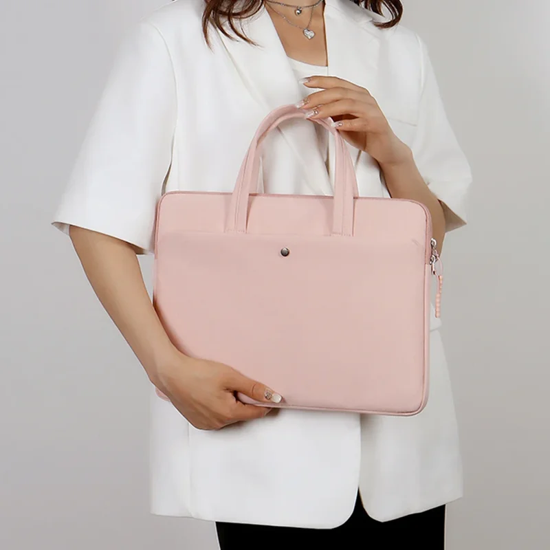 A woman in a white blazer holds a light pink laptop bag.