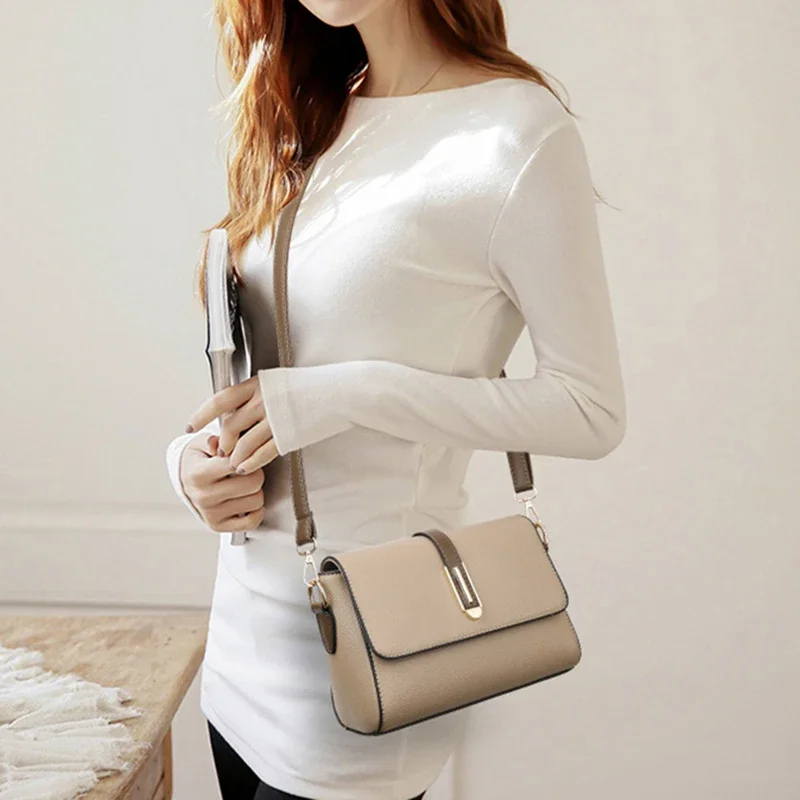 A woman in a white long-sleeved shirt carries a beige crossbody bag.