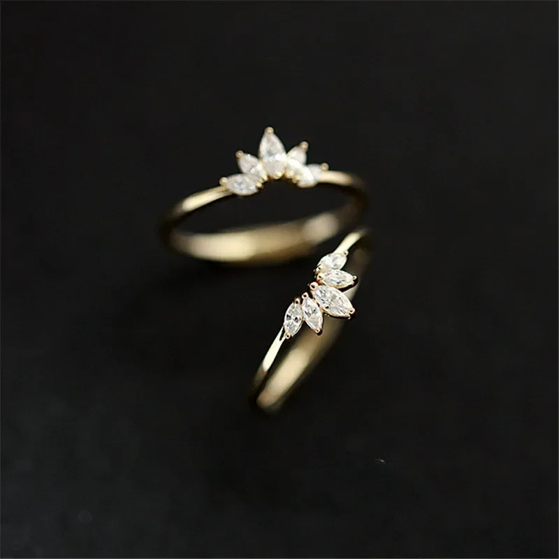 Two gold rings with marquise-cut diamonds set in a crown-like design. The rings are stacked on top of each other.