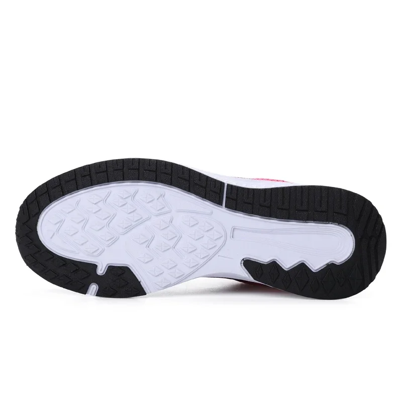 Bottom of a pink and white running shoe with a black sole.