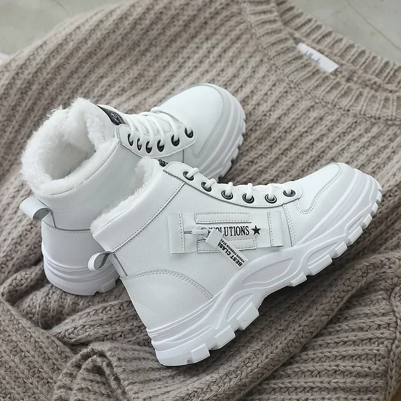 Pair of white high-top winter boots with fluffy white lining, thick soles, and a zipper detail.