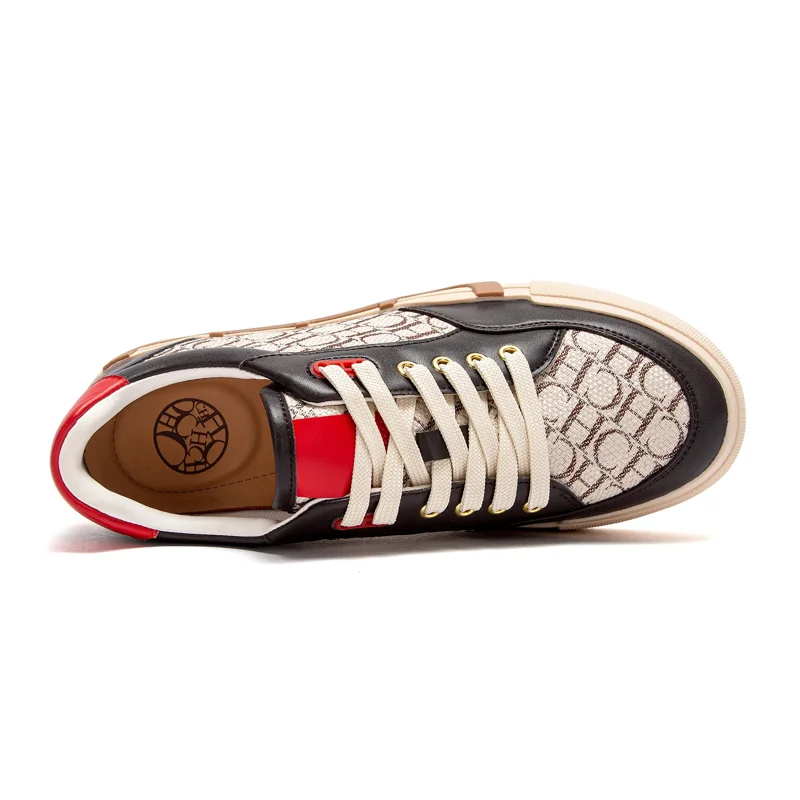Close-up view of a single black and beige sneaker with red accents. The shoe is set against a white background, showing its details clearly. The shoe's sole is beige, with a brown stripe along the edge. The upper is a combination of black leather and a beige fabric with a repeating pattern. The laces are off-white, and the eyelets are gold. The inside of the shoe has a red inner lining and a tan insole with a logo.