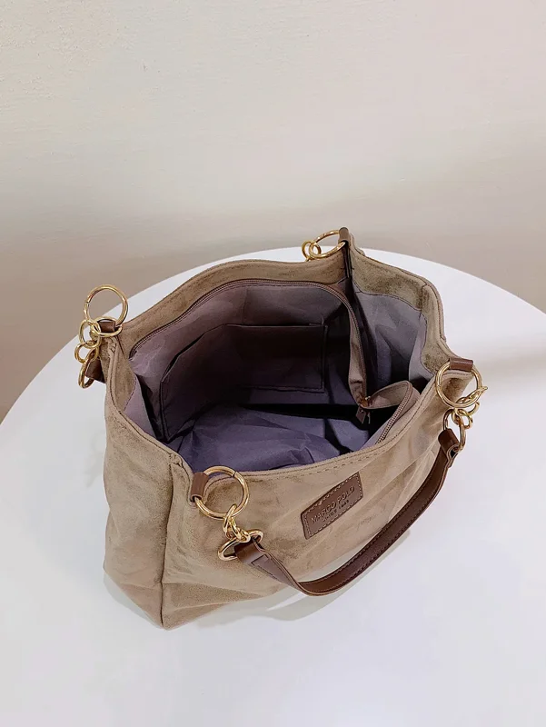 A light brown suede tote bag with gold chain straps and a brown leather handle. The bag is open and the interior is visible. The bag has a Marco Polo label.