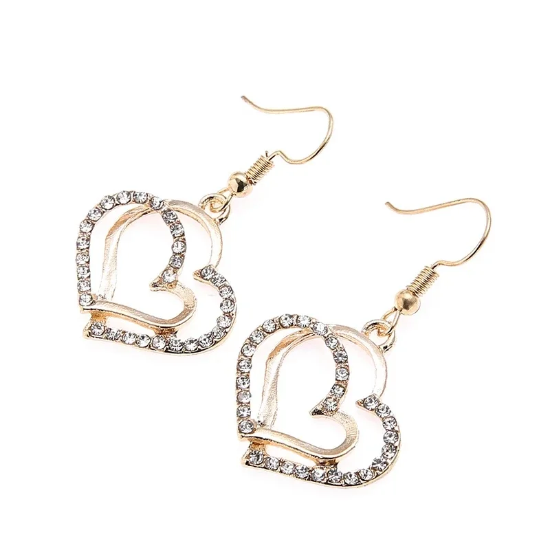 A pair of gold heart-shaped earrings with clear crystals.