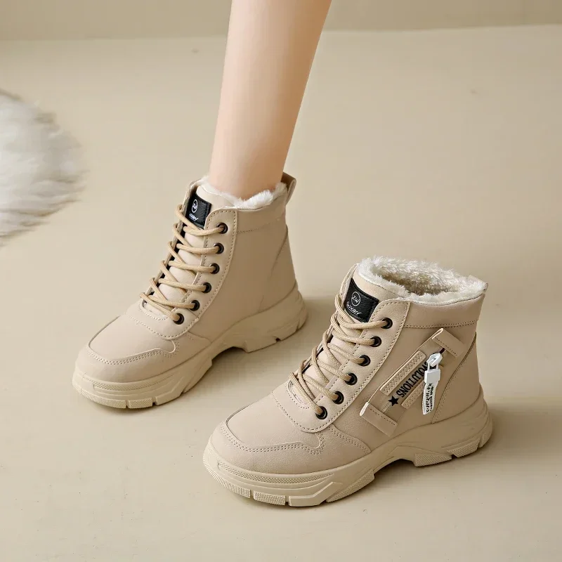 A pair of beige winter boots with fur lining. The boots are lace-up style and have a chunky sole. They are shown on a model's feet against a light beige background.