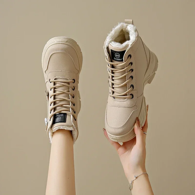 A pair of beige chunky platform lace-up boots with faux fur lining. The boots are shown being held by a person's hand and worn by a model.