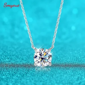 A silver necklace with a large, round, clear gemstone pendant hangs against a turquoise background.