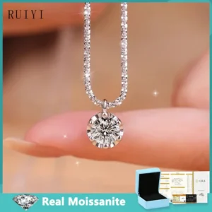 A silver necklace with a round, clear gemstone pendant rests on a finger. A light blue gift box and certificate of authenticity are shown below.