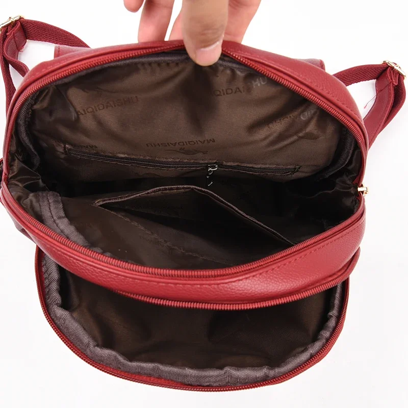 Inside of a red backpack. The backpack is open and shows the interior pockets and lining.